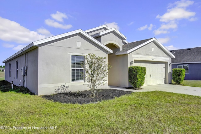 view of front of house featuring a garage and a front lawn