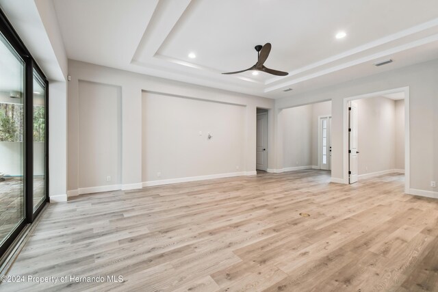 19504 Sheltered Hill Dr, Brooksville, FL 34601 - unfurnished living room with ceiling fan, a raised ceiling, light wood-type flooring, recessed lighting, and baseboards