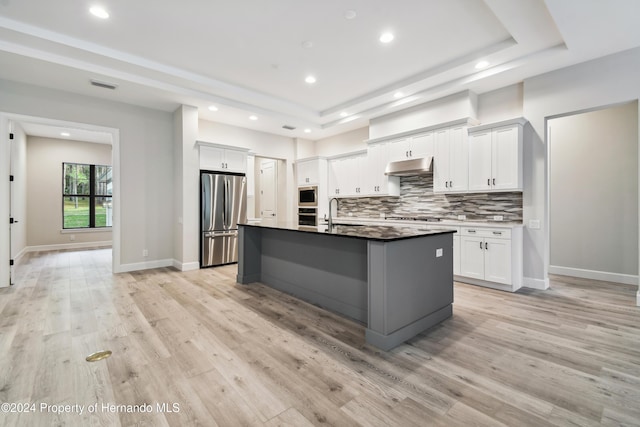 19504 Sheltered Hill Dr, Brooksville, FL 34601 - kitchen with stainless steel appliances, under cabinet range hood, recessed lighting, backsplash, and a raised ceiling