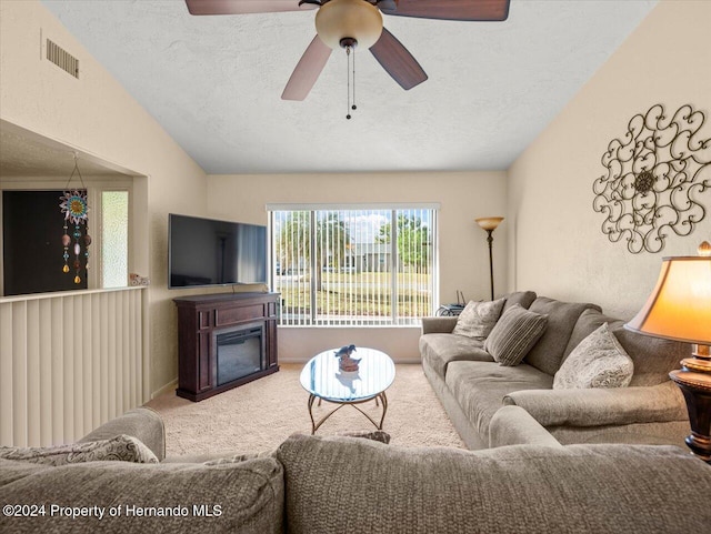 carpeted living room featuring ceiling fan, lofted ceiling, and a textured ceiling