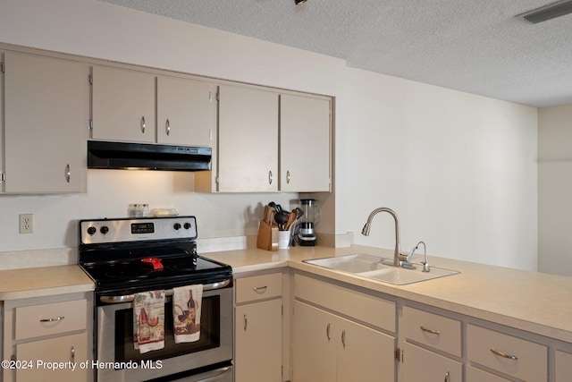 kitchen with a textured ceiling, stainless steel range with electric cooktop, and sink