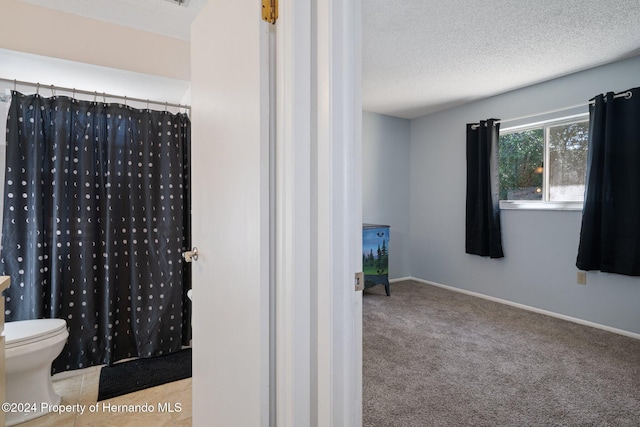 bathroom featuring walk in shower, a textured ceiling, and toilet