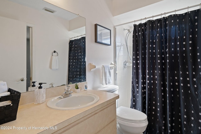 bathroom with vanity, toilet, and walk in shower