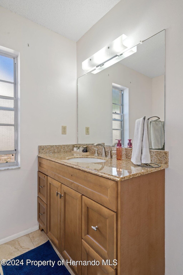 bathroom featuring vanity, a textured ceiling, and tile patterned flooring