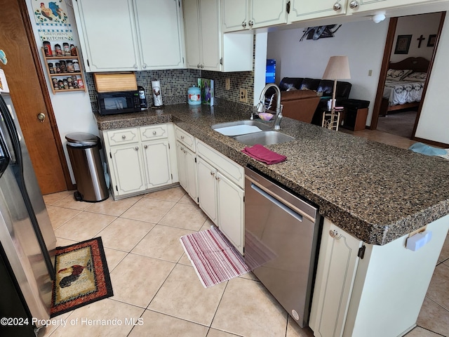 kitchen with white cabinetry, sink, stainless steel dishwasher, kitchen peninsula, and decorative backsplash