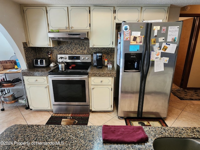 kitchen with ventilation hood, backsplash, light tile patterned floors, and stainless steel appliances