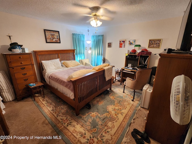 carpeted bedroom featuring ceiling fan and a textured ceiling