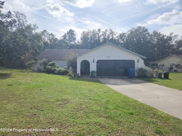 ranch-style house featuring a front lawn and a garage