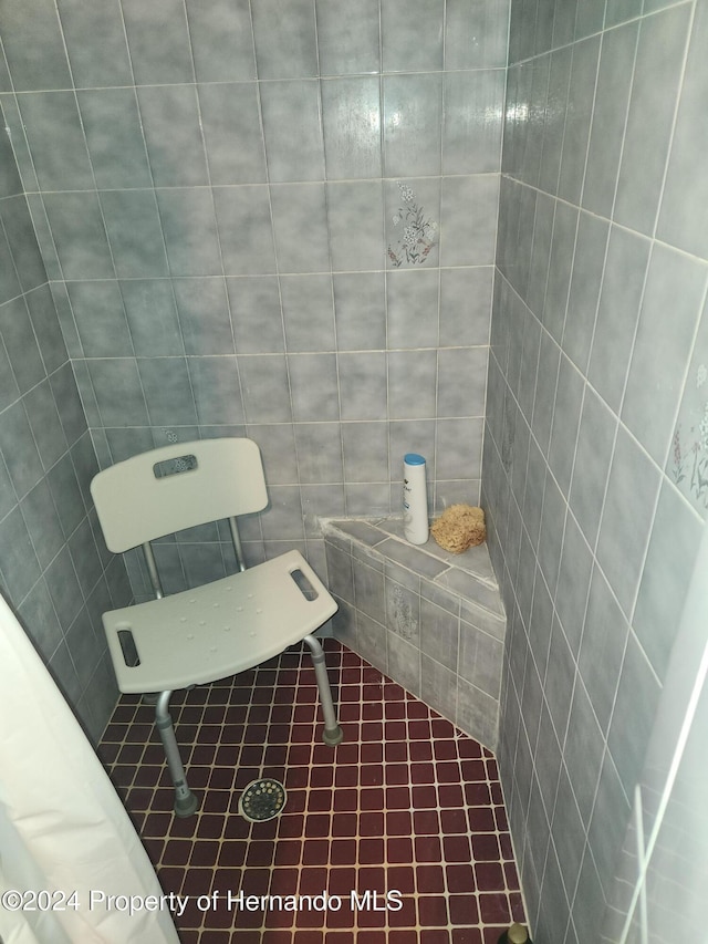 bathroom with tile patterned floors and tile walls