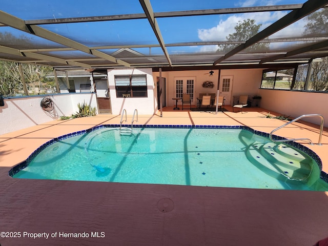 pool featuring glass enclosure, french doors, and a patio area