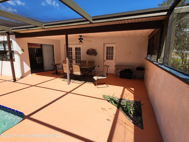 view of patio with a ceiling fan, a lanai, and french doors