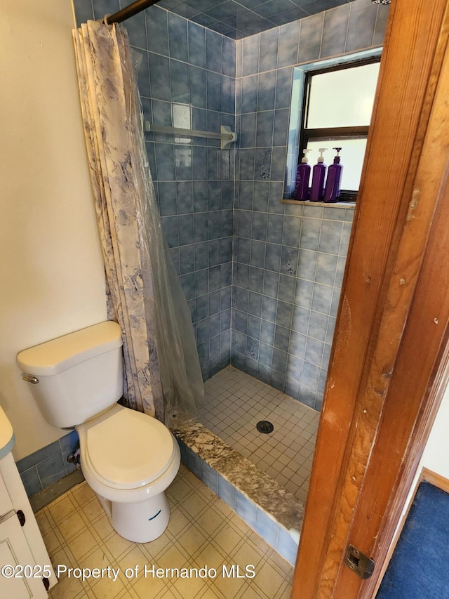 full bathroom with a shower stall, toilet, and tile patterned floors