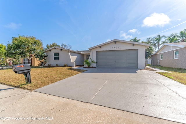 ranch-style home with a garage and a front lawn