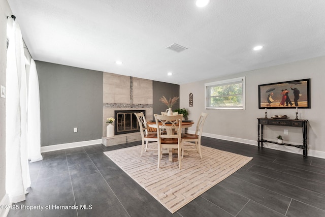 dining room featuring a fireplace and a textured ceiling