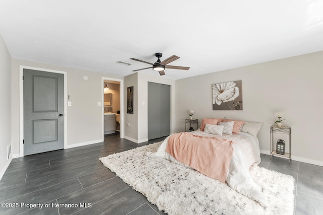 bedroom featuring dark hardwood / wood-style flooring, ensuite bathroom, ceiling fan, and a closet