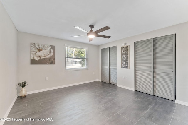 unfurnished bedroom featuring two closets and ceiling fan