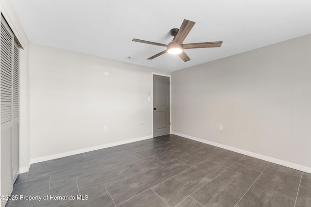 unfurnished bedroom with ceiling fan and a closet