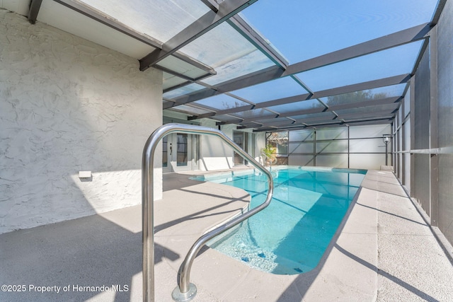 view of pool with a patio and glass enclosure