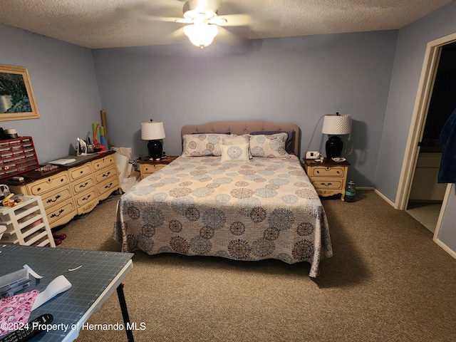 carpeted bedroom featuring ceiling fan and a textured ceiling