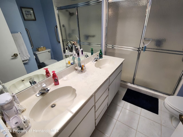 bathroom featuring tile patterned flooring, vanity, toilet, and walk in shower