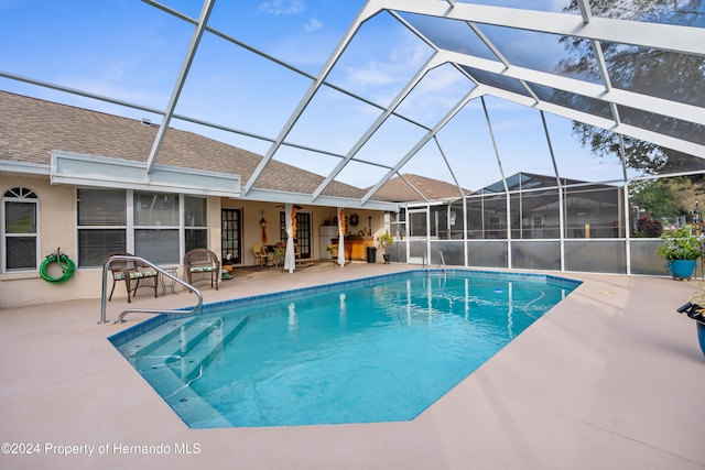 view of pool featuring ceiling fan, a lanai, and a patio