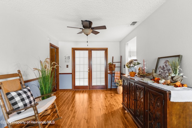 doorway to outside featuring ceiling fan, light hardwood / wood-style floors, a textured ceiling, and french doors