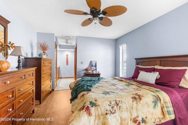 bedroom featuring a textured ceiling, light hardwood / wood-style floors, and ceiling fan