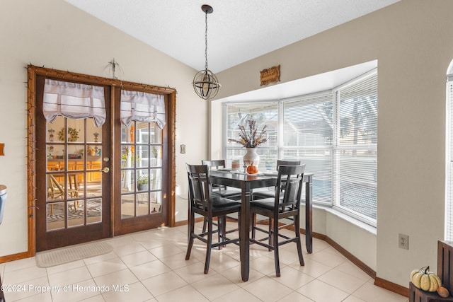 dining space featuring light tile patterned floors, a textured ceiling, and vaulted ceiling