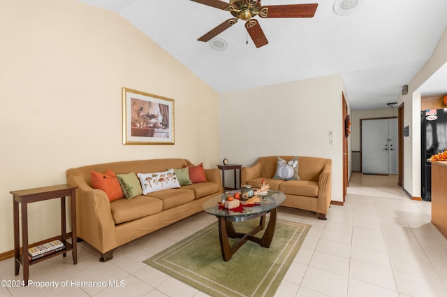 living room with ceiling fan, light tile patterned floors, and vaulted ceiling