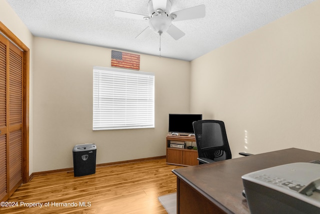 office area featuring ceiling fan, light hardwood / wood-style floors, and a textured ceiling