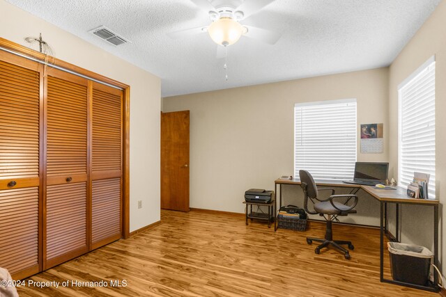 home office featuring ceiling fan, a textured ceiling, and light hardwood / wood-style flooring