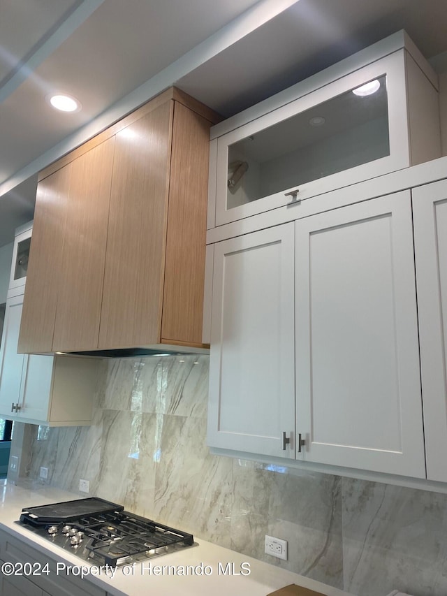 4817 Majestic Hills Loop, Brooksville, FL 34601 - kitchen featuring stainless steel gas cooktop, glass insert cabinets, tasteful backsplash, light countertops, and recessed lighting