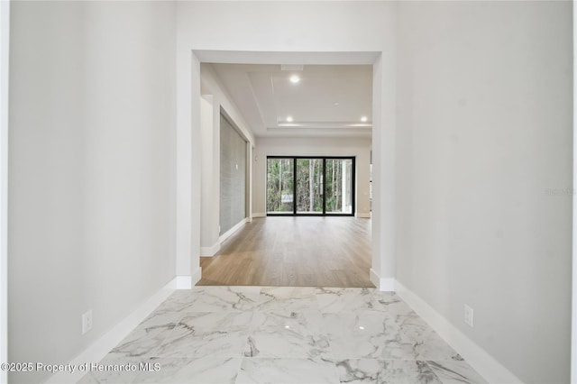 hallway featuring a raised ceiling