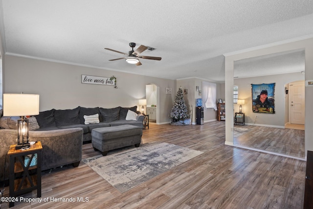 living room with ceiling fan, ornamental molding, a textured ceiling, and hardwood / wood-style flooring