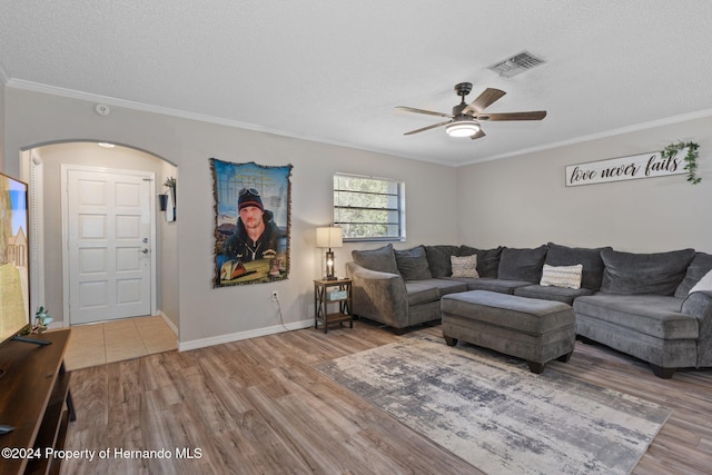 living room with hardwood / wood-style floors, a textured ceiling, ceiling fan, and ornamental molding