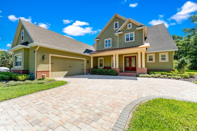 craftsman-style house featuring a porch, a garage, and french doors