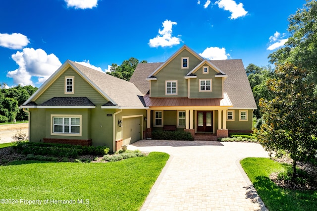 craftsman-style home with a front yard, french doors, and a garage