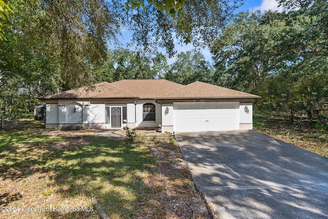 single story home featuring a front lawn and a garage