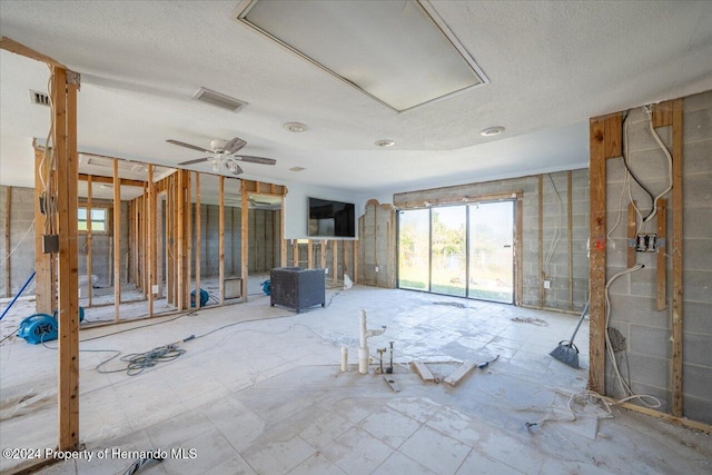 miscellaneous room featuring ceiling fan and a textured ceiling