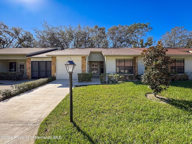 ranch-style house featuring a garage and a front lawn