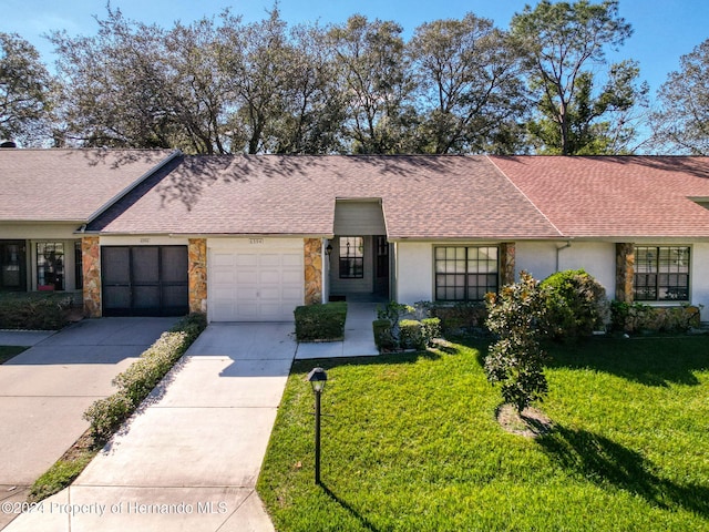 ranch-style house with a garage and a front lawn