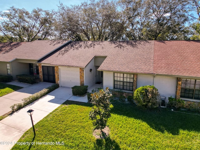 ranch-style house with a garage and a front lawn