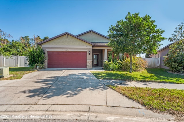 craftsman-style house with a garage and a front lawn