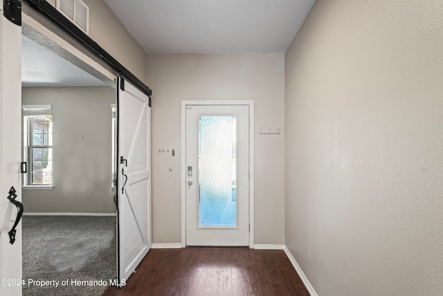 foyer entrance featuring a barn door and dark hardwood / wood-style flooring