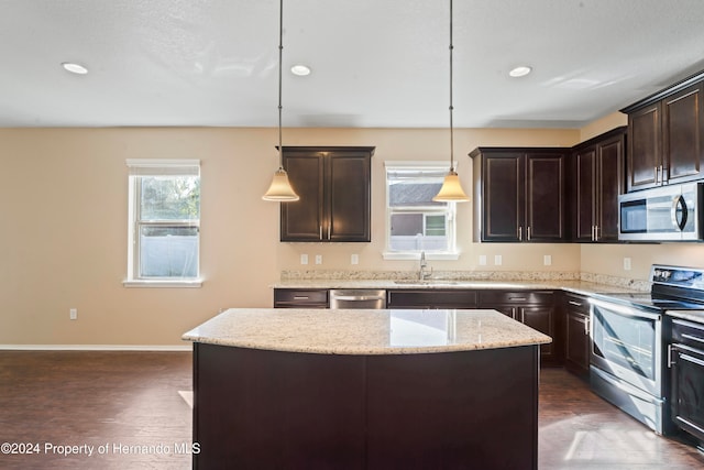 kitchen with pendant lighting, a center island, stainless steel appliances, and dark wood-type flooring