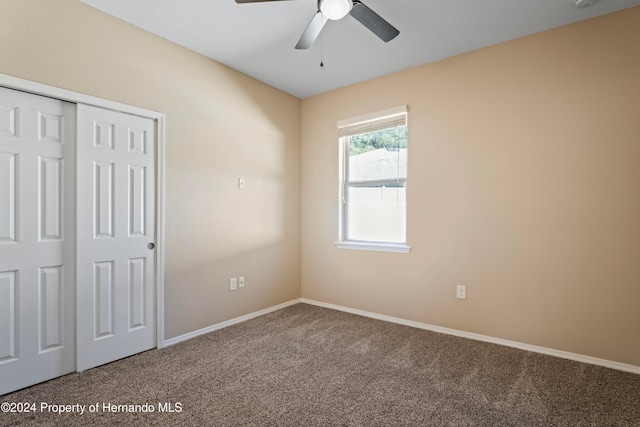 unfurnished bedroom with carpet, ceiling fan, and a closet