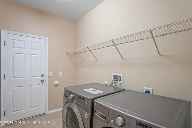 washroom with washer and dryer and light tile patterned floors