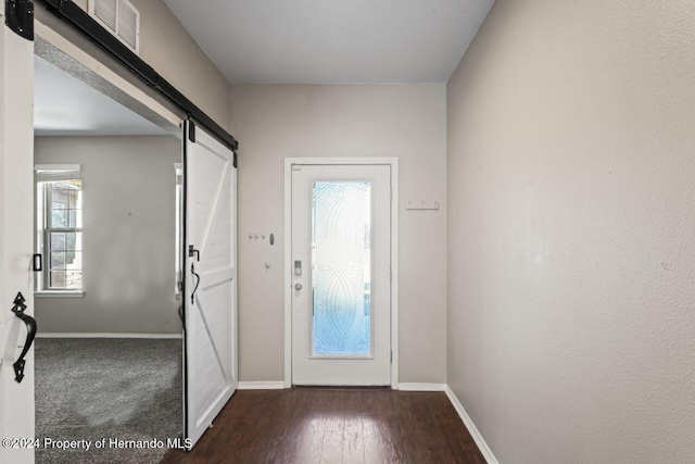 doorway to outside with dark hardwood / wood-style flooring and a barn door