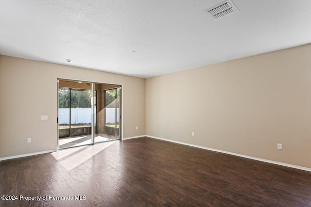 spare room with dark hardwood / wood-style flooring