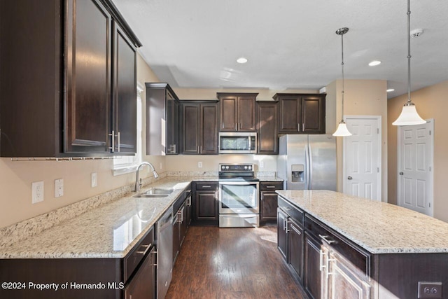 kitchen featuring a center island, sink, appliances with stainless steel finishes, decorative light fixtures, and dark hardwood / wood-style flooring